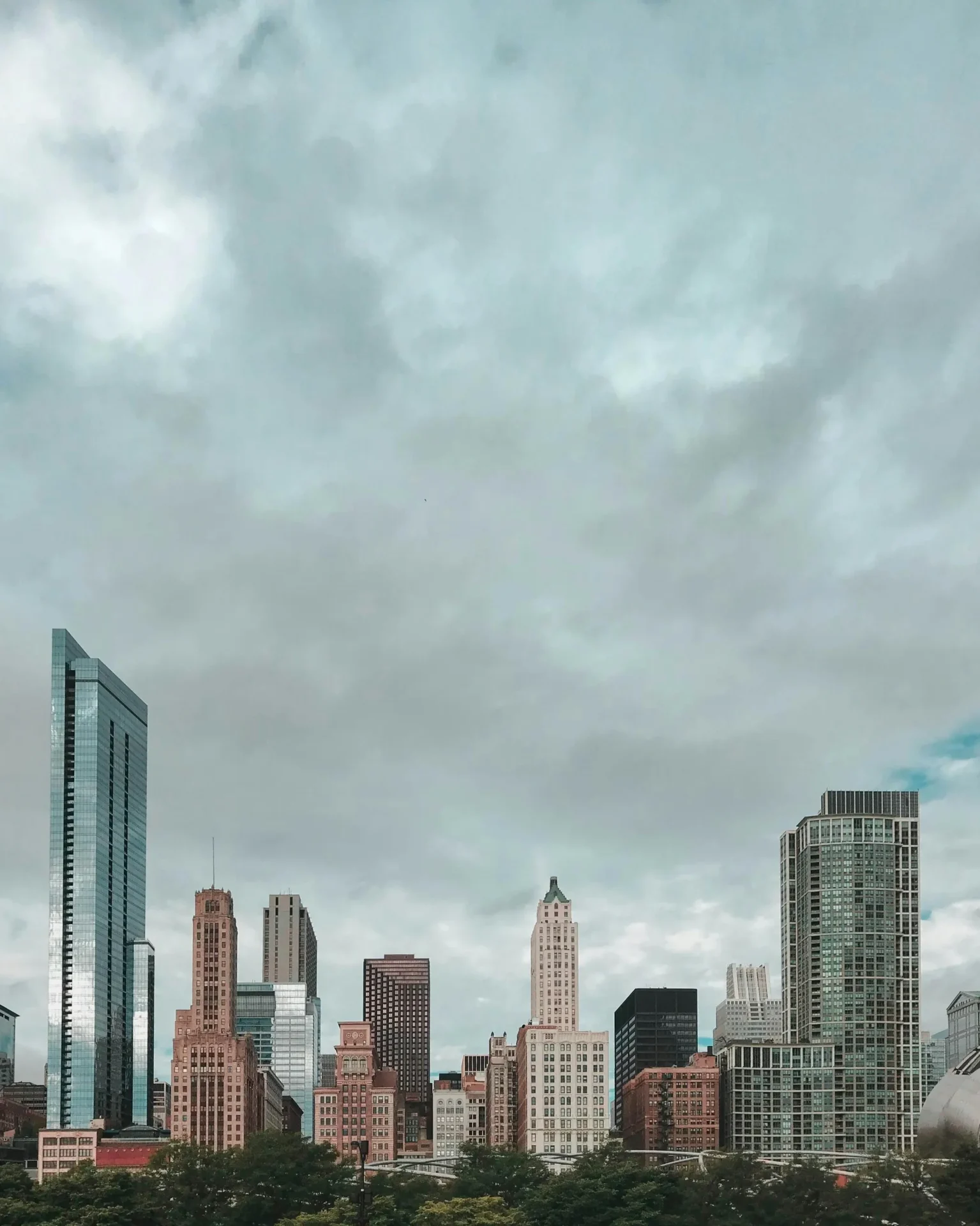 A city skyline with many skyscrapers under cloudy skies.